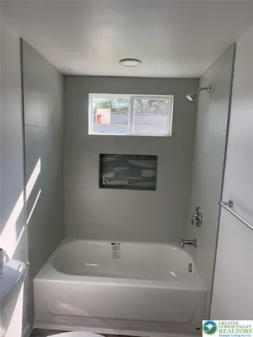 a bathroom with a bathtub and a window