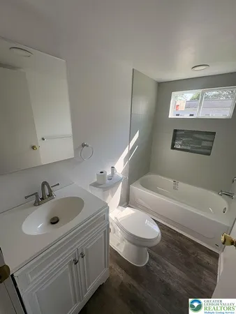 a bathroom with a toilet sink and mirror