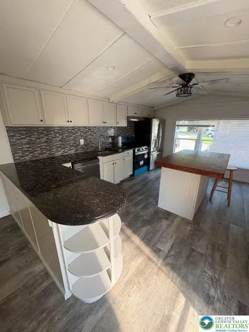 a kitchen with kitchen island granite countertop a sink and a stove