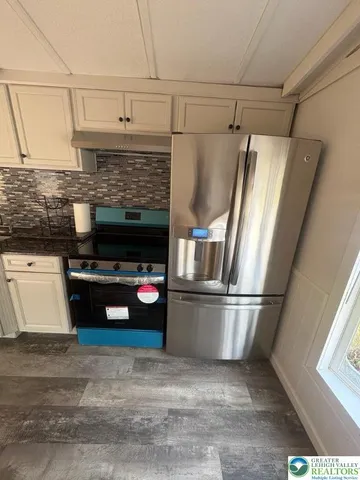 a kitchen with kitchen island a refrigerator and a stove
