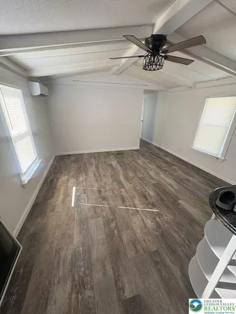 a view of a room with a ceiling fan and a rug