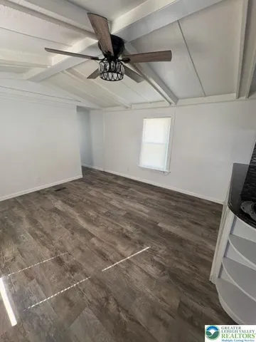 a view of a room with a ceiling fan and a rug