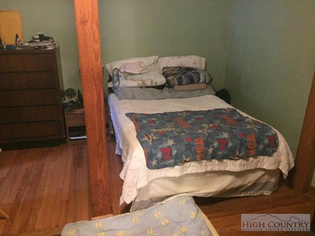 275 Parker Road Creston, NC 28615 - Photo 11 of 31 a bed sitting in a bedroom next to a cabinet
