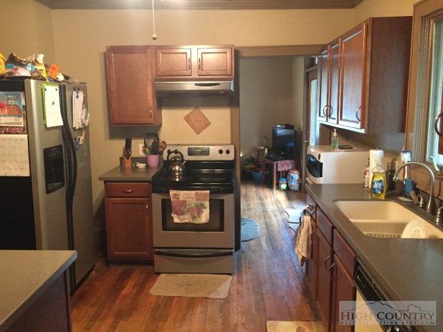 275 Parker Road Creston, NC 28615 - Photo 5 of 31 a kitchen with stainless steel appliances granite countertop a refrigerator a stove and a sink with wooden floor