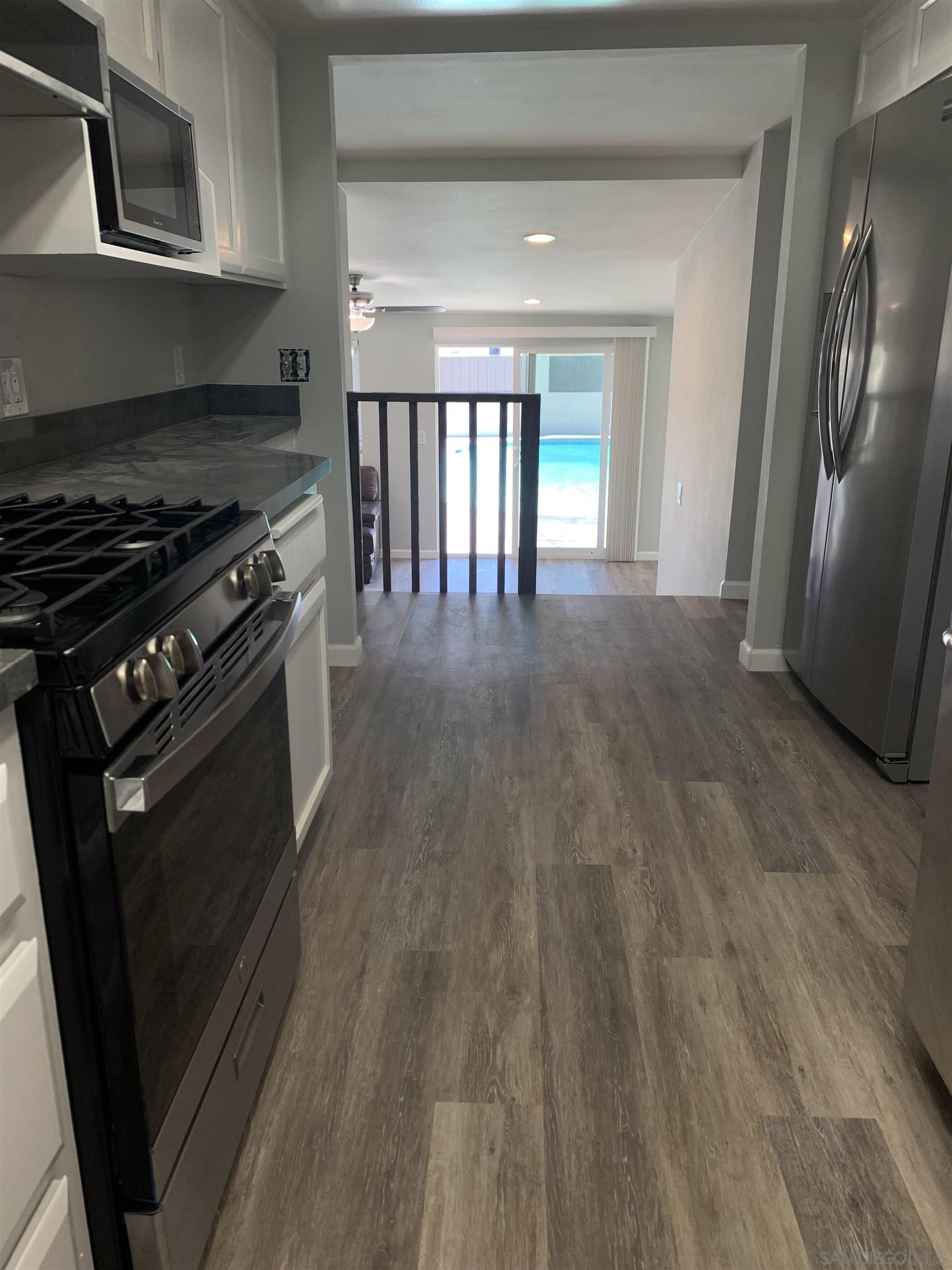 377 El Monte Road El Cajon, CA 92020 - Photo 12 of 19 a view of a kitchen with stainless steel appliances wooden floor and a window