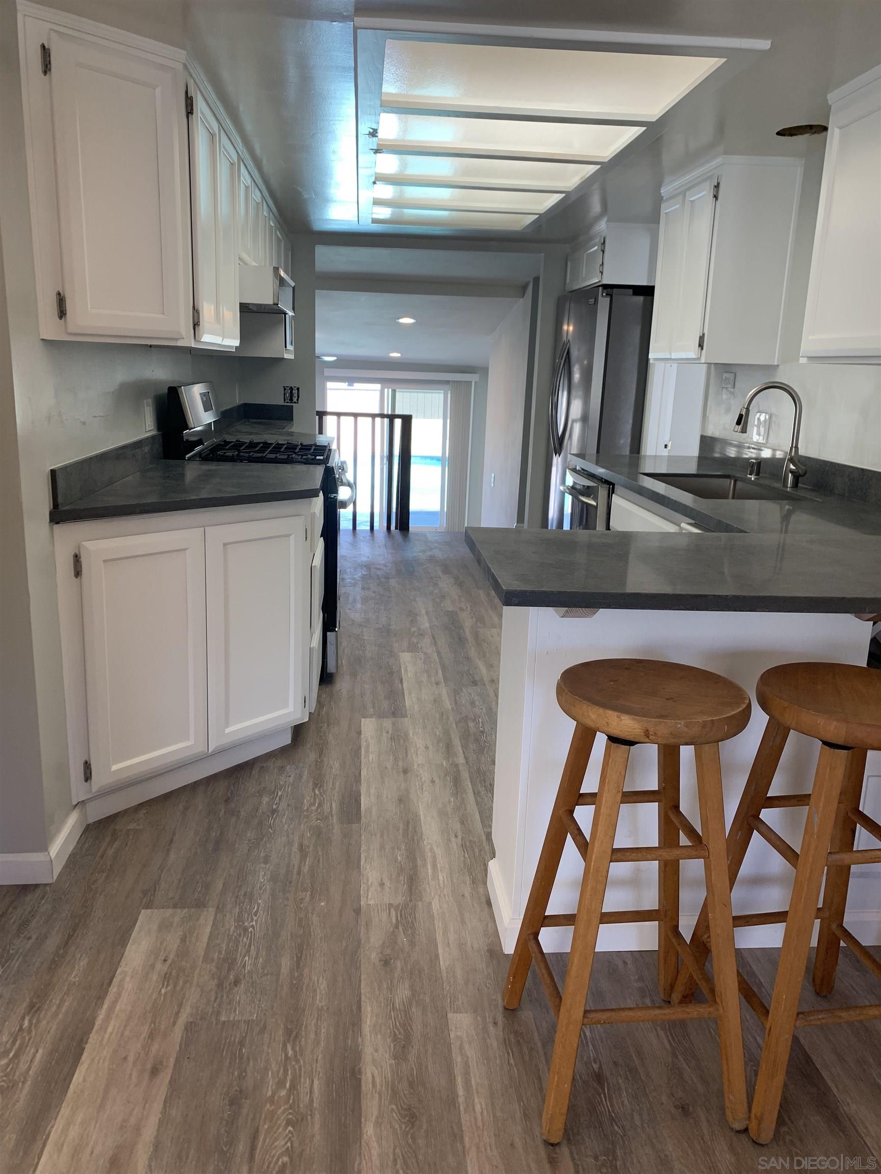 377 El Monte Road El Cajon, CA 92020 - Photo 5 of 19 a kitchen with granite countertop wooden floors furniture and center island