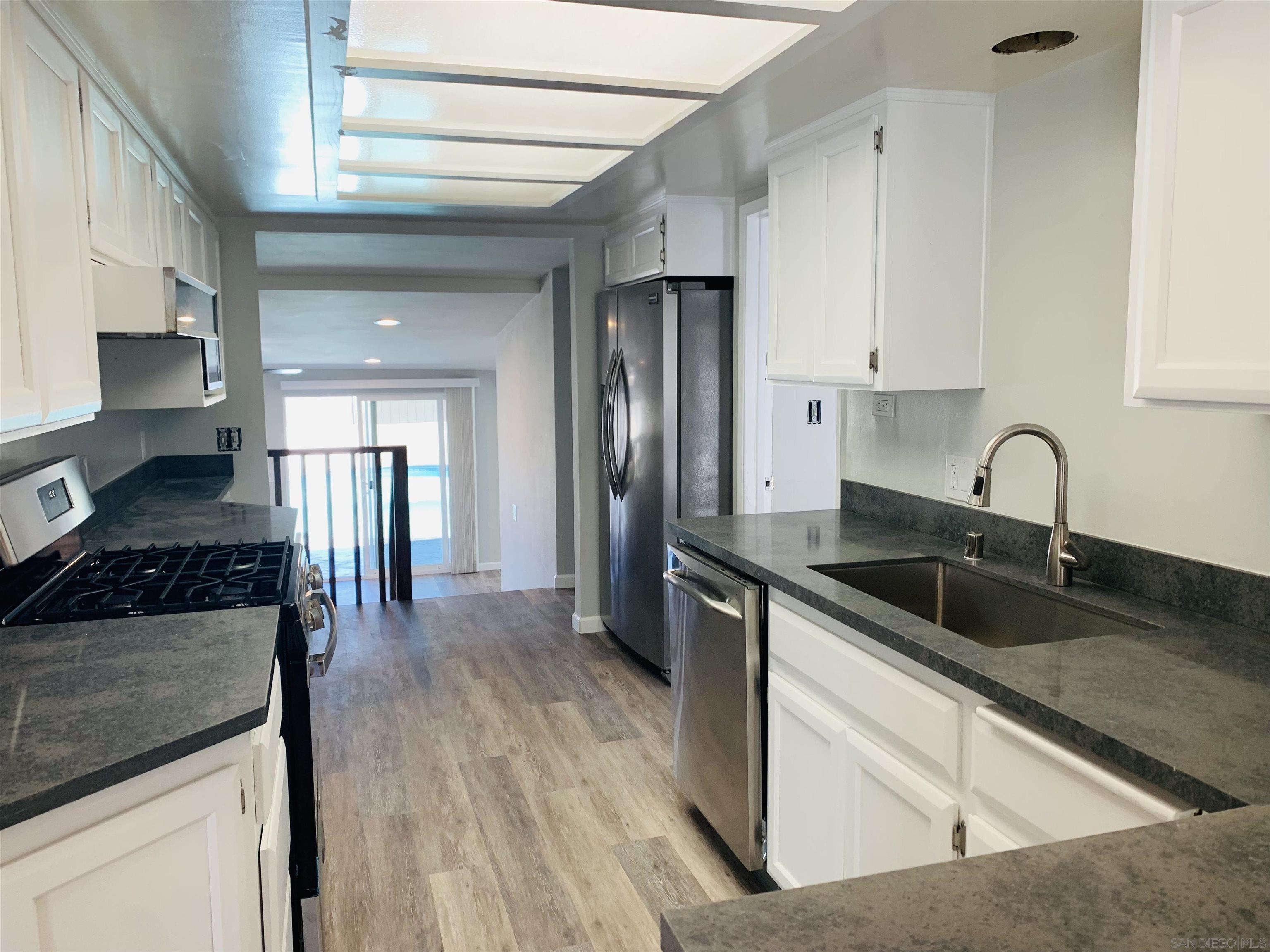 377 El Monte Road El Cajon, CA 92020 - Photo 7 of 19 a kitchen with stainless steel appliances granite countertop a sink stove and refrigerator
