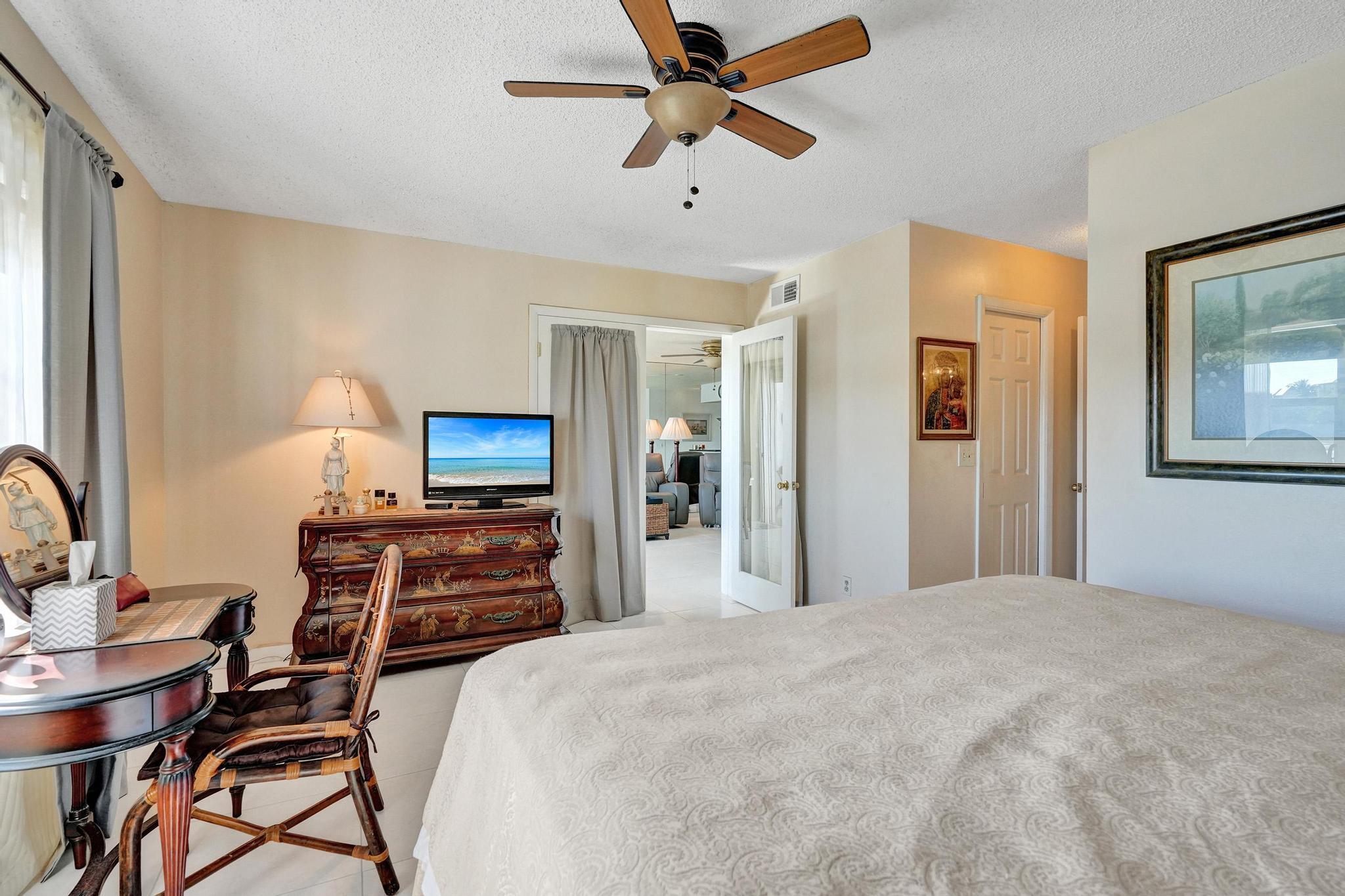 231 East Lantana Road, Unit 204 Lantana, FL 33462 - Photo 14 of 63 a bedroom with a bed and a chandelier