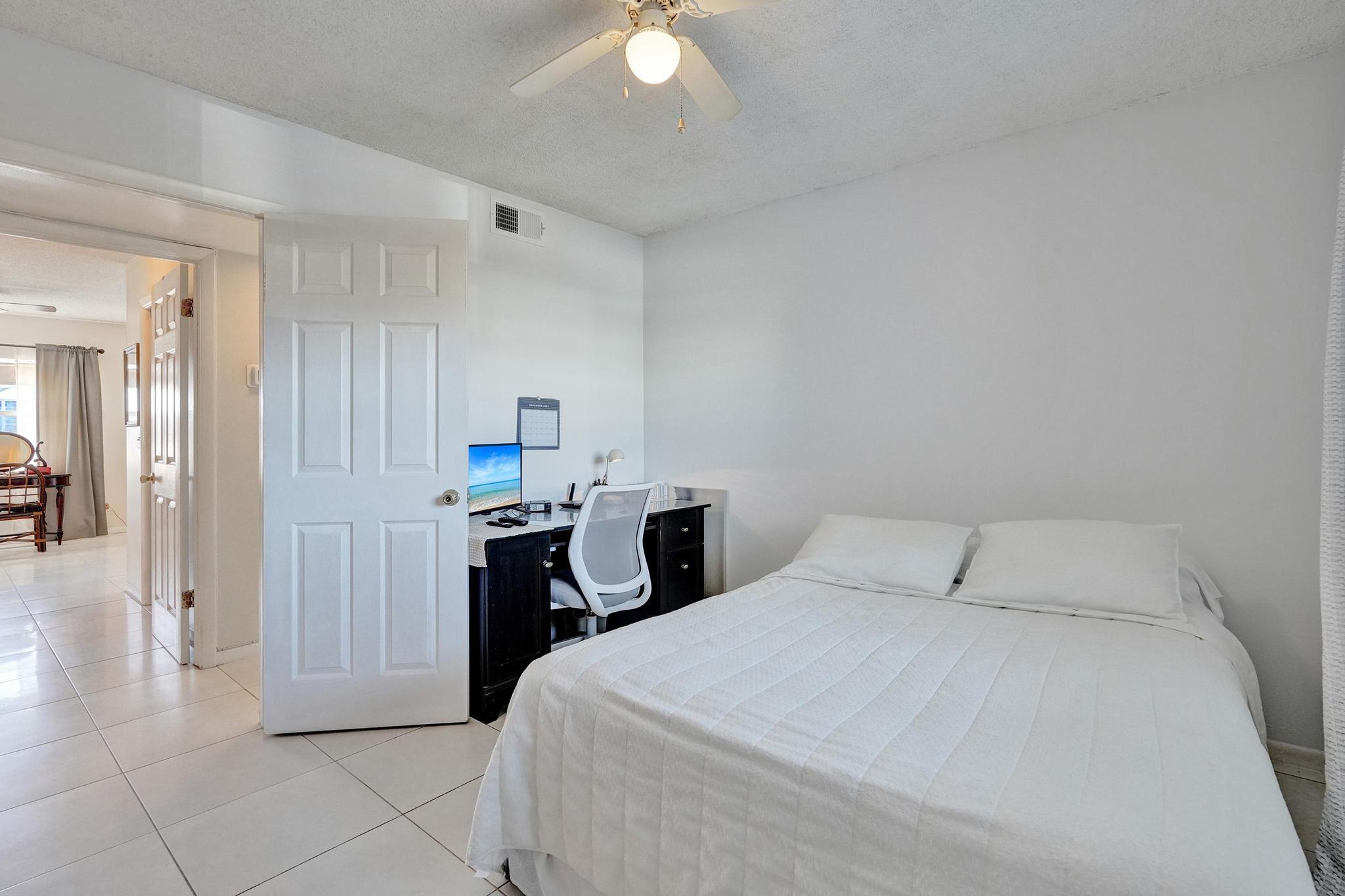 231 East Lantana Road, Unit 204 Lantana, FL 33462 - Photo 22 of 63 a bedroom with a bed and a chandelier