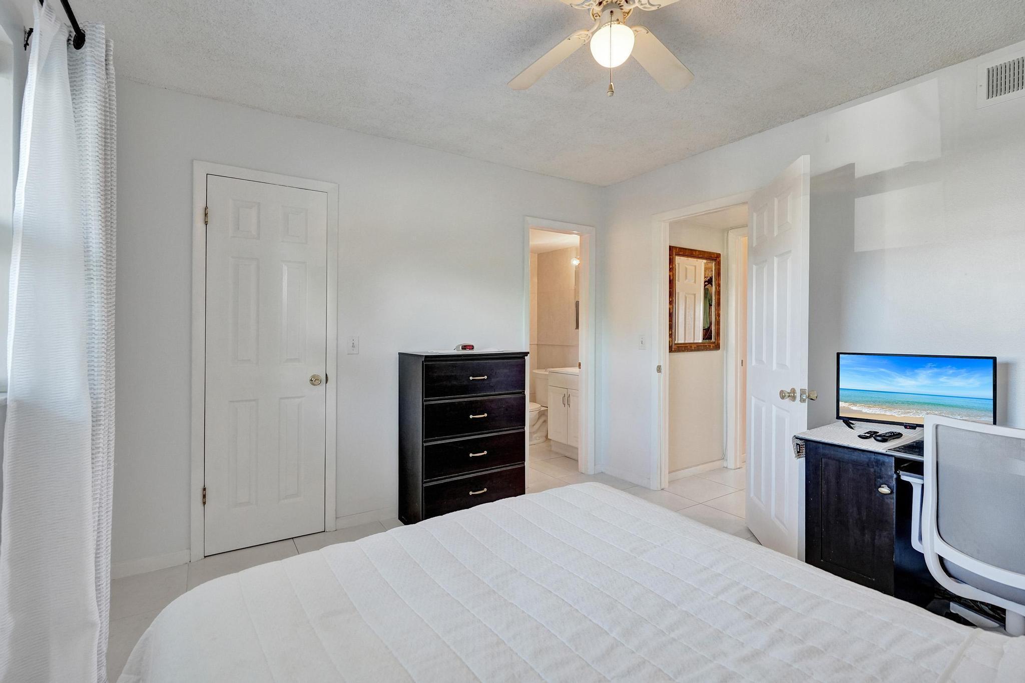 231 East Lantana Road, Unit 204 Lantana, FL 33462 - Photo 24 of 63 a bedroom with a bed and a chandelier