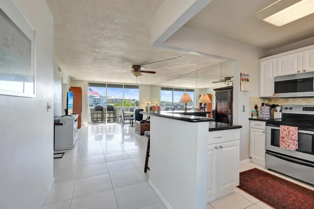 a kitchen with stainless steel appliances granite countertop a refrigerator a stove a sink and white cabinets