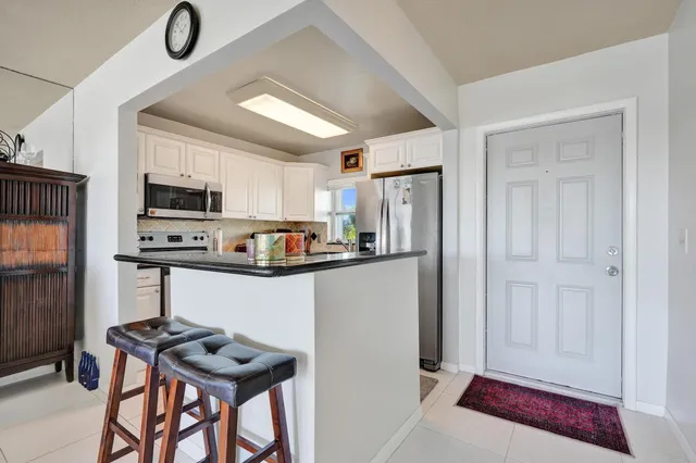 a kitchen with stainless steel appliances a refrigerator sink and microwave