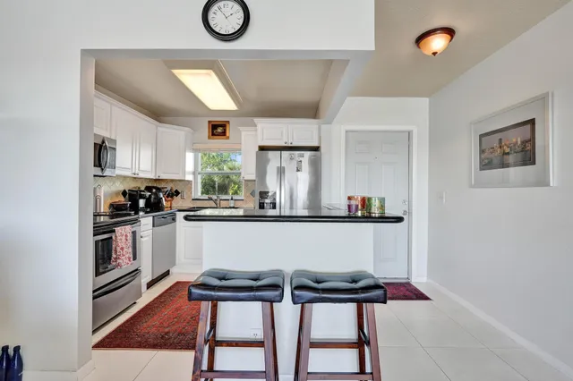 a living room with furniture and kitchen view