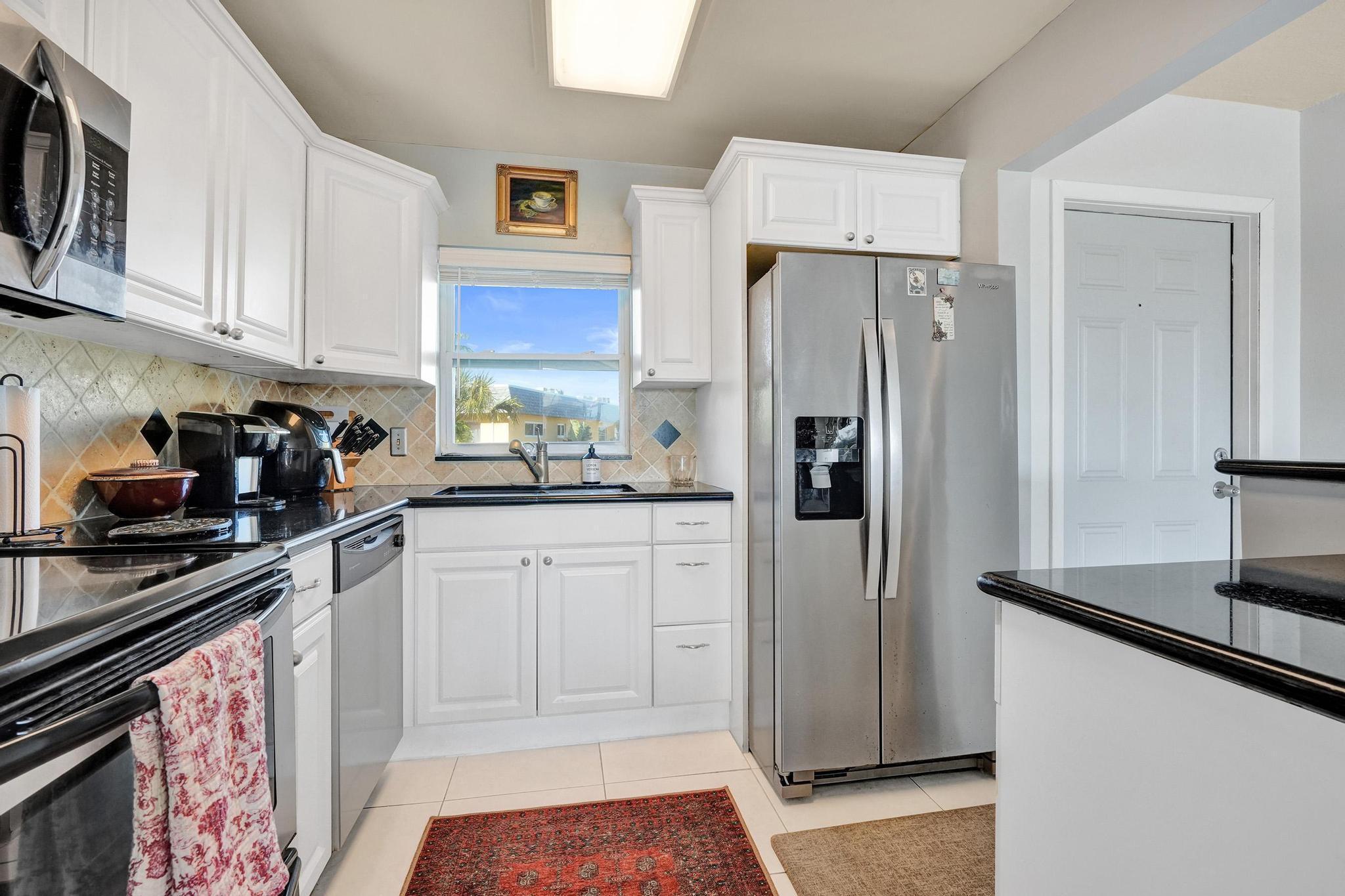 231 East Lantana Road, Unit 204 Lantana, FL 33462 - Photo 30 of 63 a kitchen with stainless steel appliances a refrigerator and cabinets