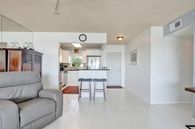 a living room with furniture and kitchen view