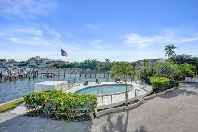 a view of a swimming pool with a lawn chairs under an umbrella