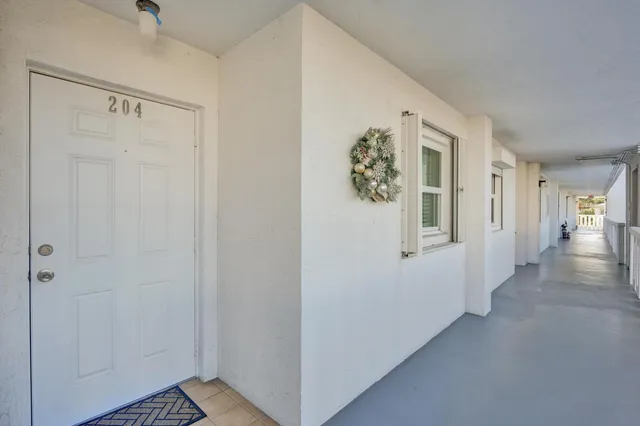 a spacious bedroom with a bed a chandelier and mirror