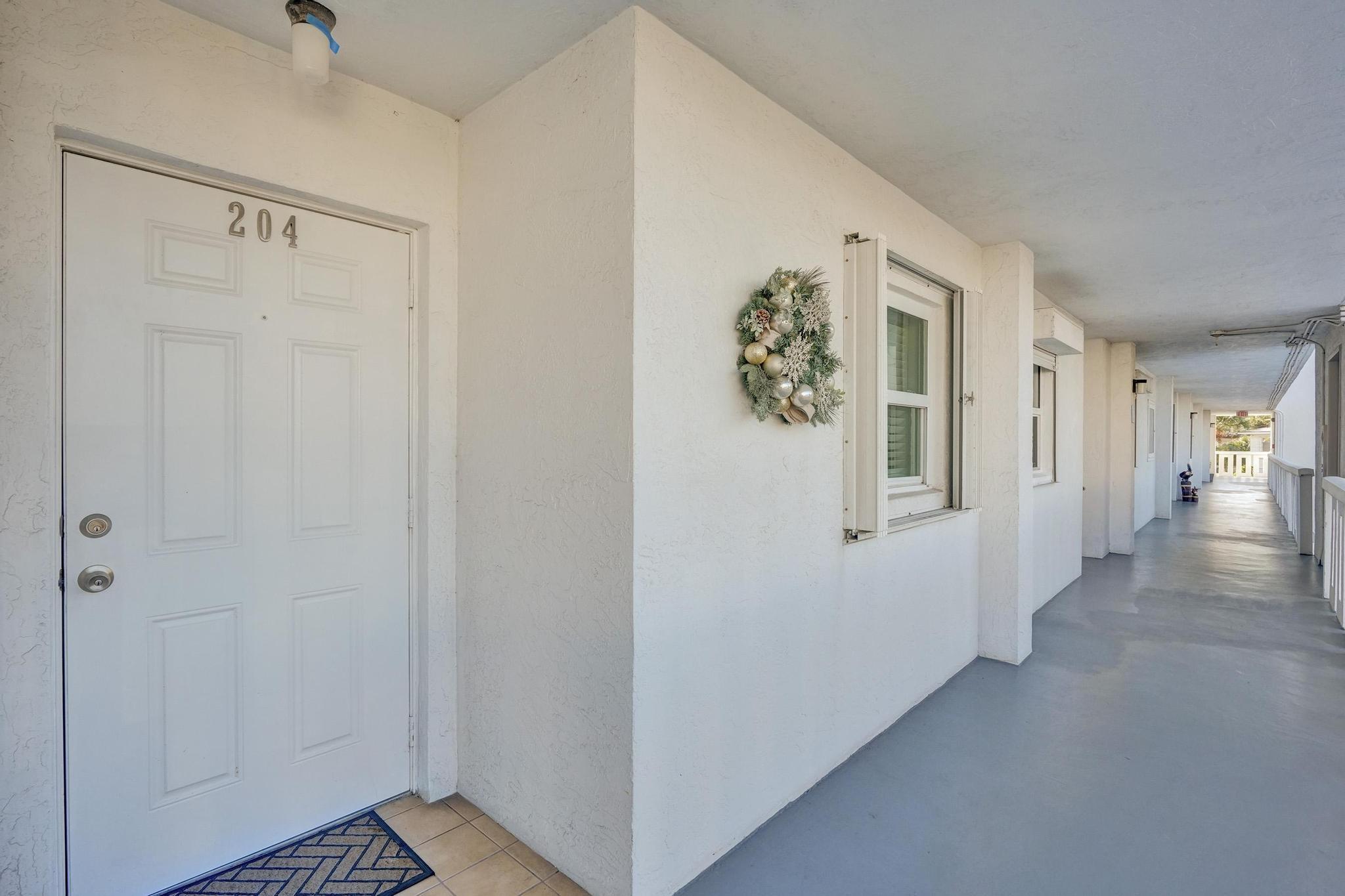 231 East Lantana Road, Unit 204 Lantana, FL 33462 - Photo 8 of 63 a view of a hallway with paintings on the wall