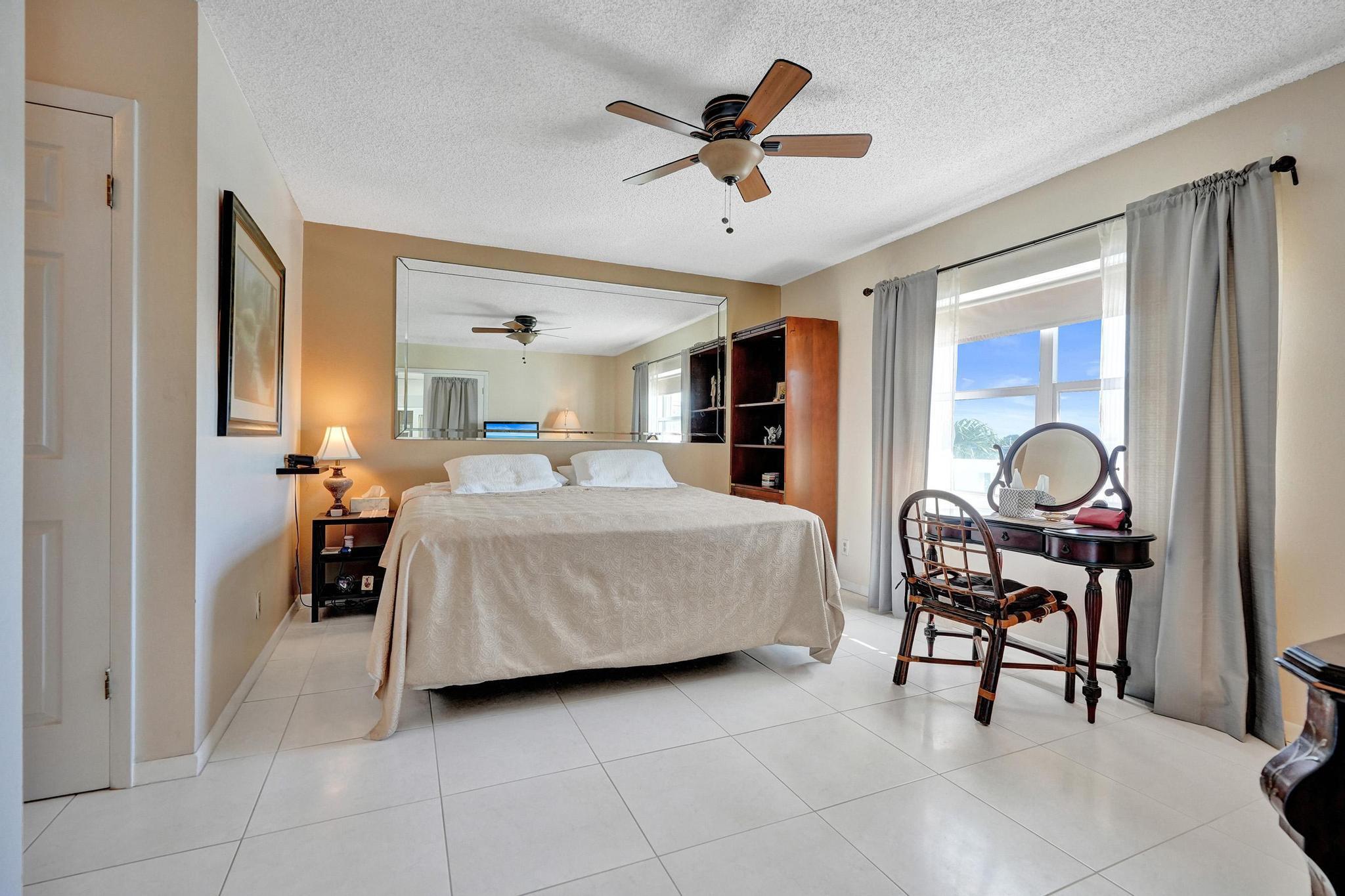 231 East Lantana Road, Unit 204 Lantana, FL 33462 - Photo 10 of 63 a bedroom with a bed and a chandelier