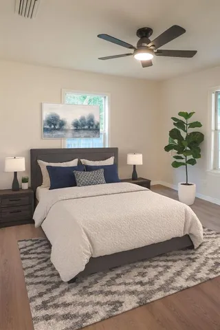 a view of empty room with wooden floor and fan