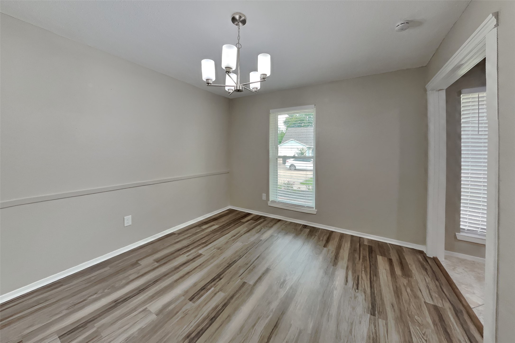 10015 Rippling Fields Drive Houston, TX 77064 - Photo 9 of 24 wooden floor in an empty room with a window