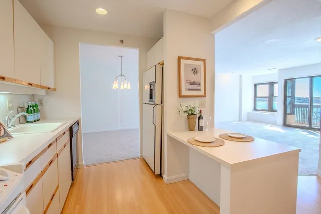 a kitchen with stainless steel appliances granite countertop a sink and cabinets with wooden floor