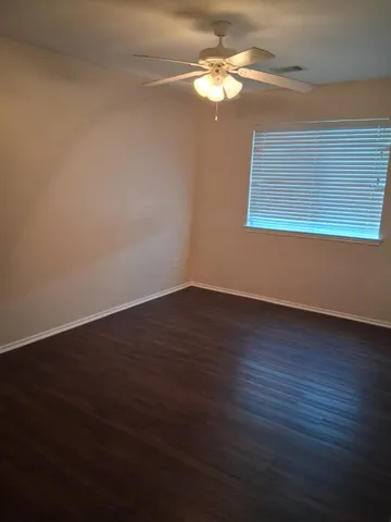 a view of a room with wooden floor and windows
