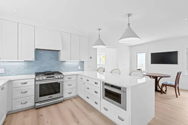 a kitchen with white cabinets stainless steel appliances and sink