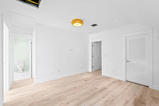 a view of empty room with window and wooden floor