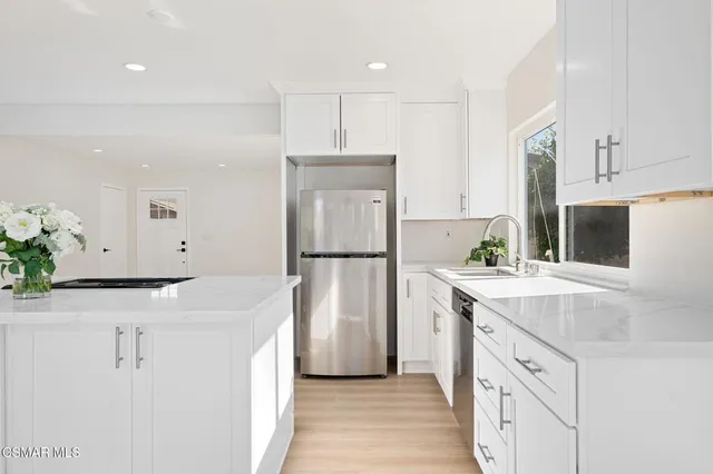 a kitchen with stainless steel appliances a refrigerator sink and cabinets