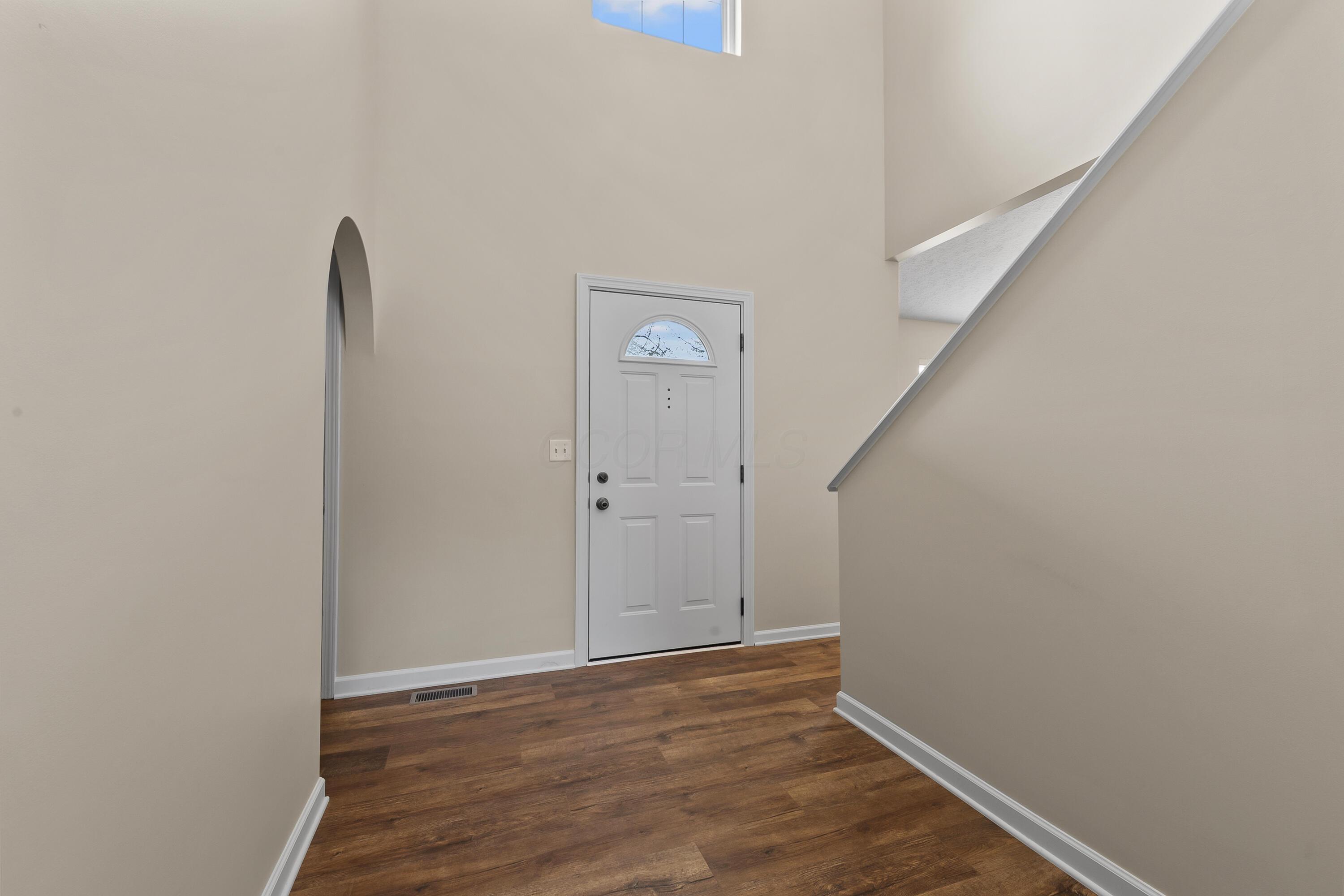 30 Tabilore Loop Delaware, OH 43015 - Photo 4 of 55 • New luxury vinyl plank flooring ~ 2025 • Tan painted walls • Two-story ceiling • Chandelier • Coat closet with bi-fold doors