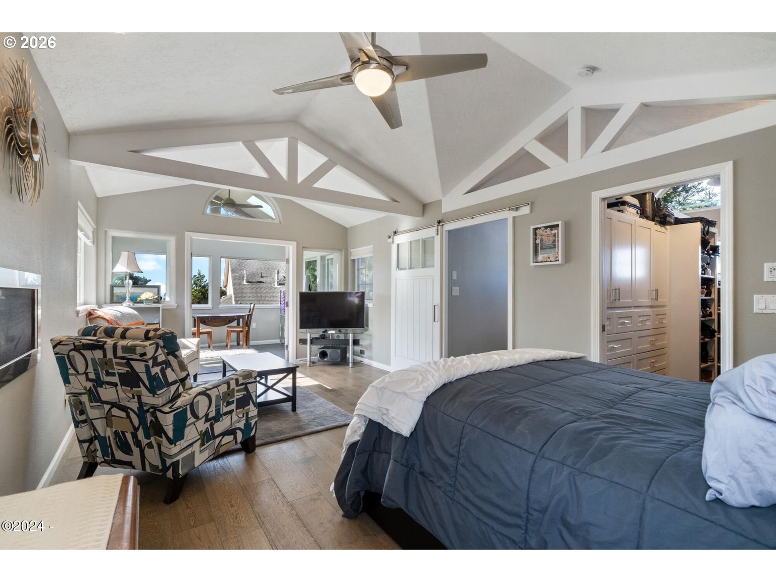 465 Edgewater Depoe Bay, OR 97341 - Photo 31 of 48 a bedroom with a bed a chandelier and flat screen tv