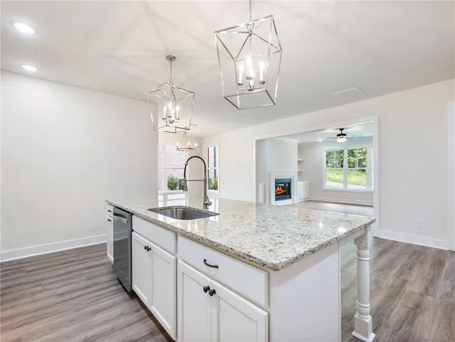 a kitchen with a sink a counter space and wooden floor