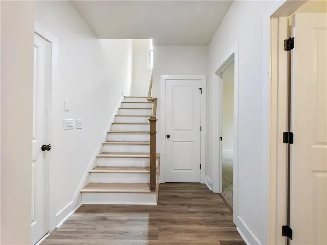 a view of a hallway with wooden floor and entryway