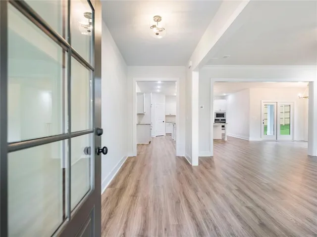 a view of a hallway with wooden floor and staircase