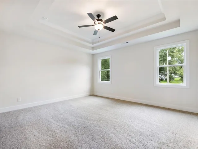 an empty room with a ceiling fan and window