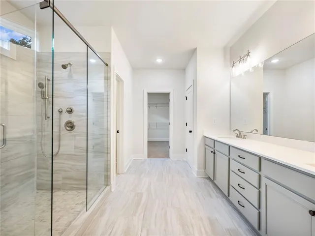 a spacious bathroom with a double vanity sink mirror and shower