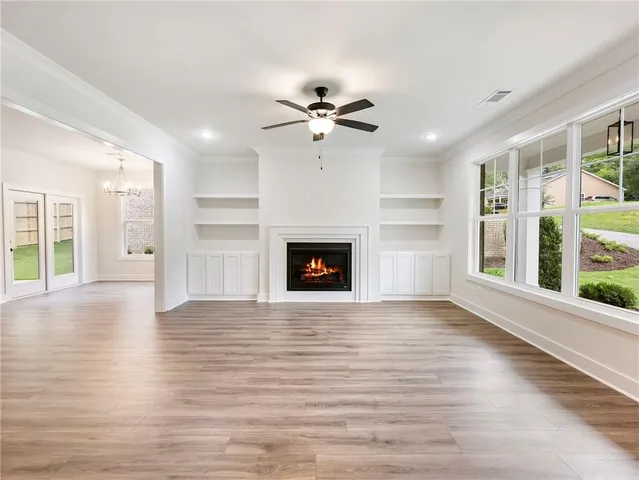 a view of an empty room with a fireplace and a window