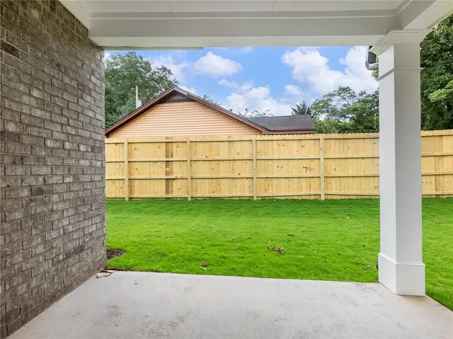 a view of white house with a big yard and potted plants