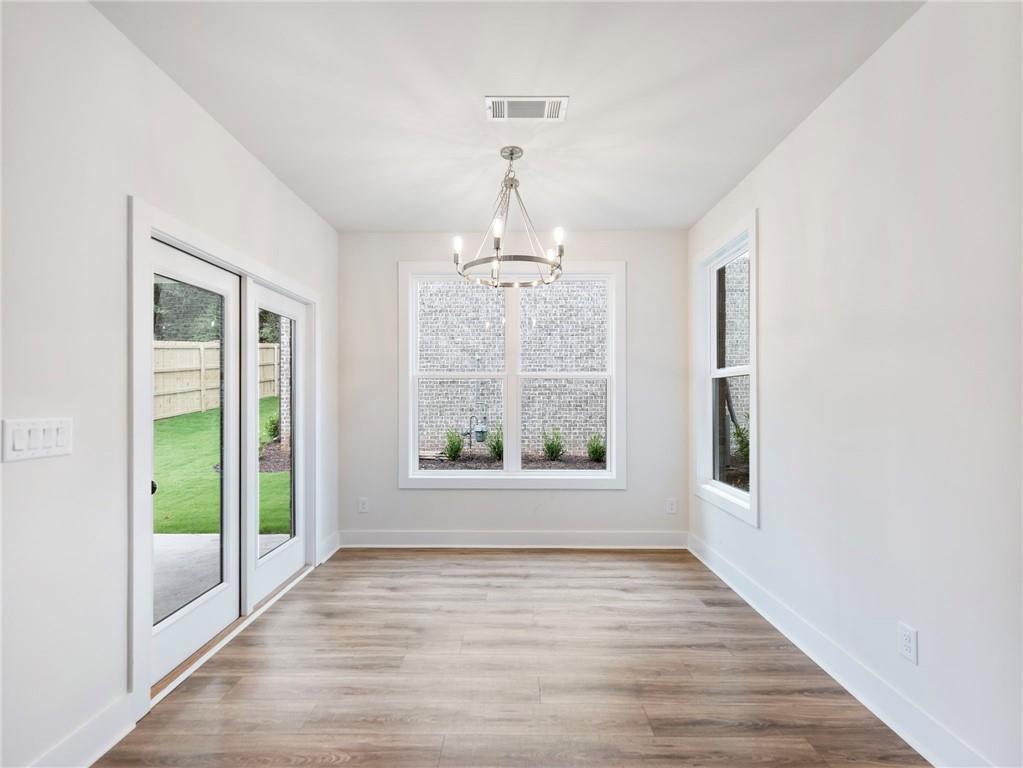 490 Jackson Street Buford, GA 30518 - Photo 7 of 46 a view of an empty room with wooden floor and a window
