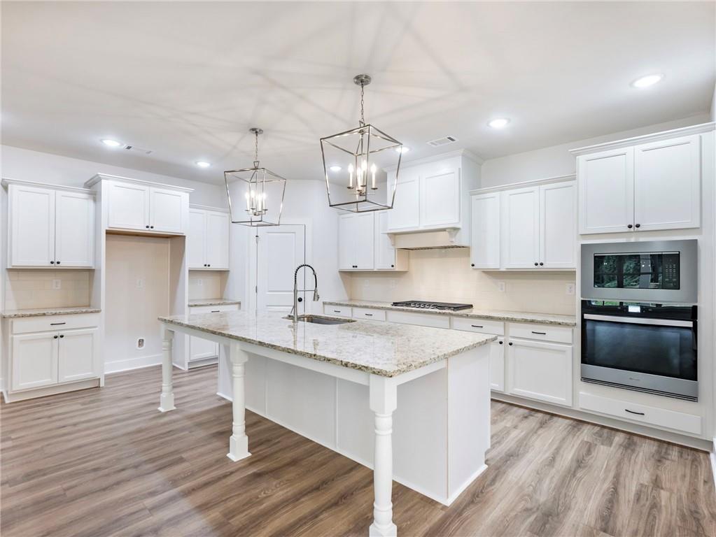 490 Jackson Street Buford, GA 30518 - Photo 9 of 46 a large kitchen with stainless steel appliances granite countertop a stove a sink and a refrigerator