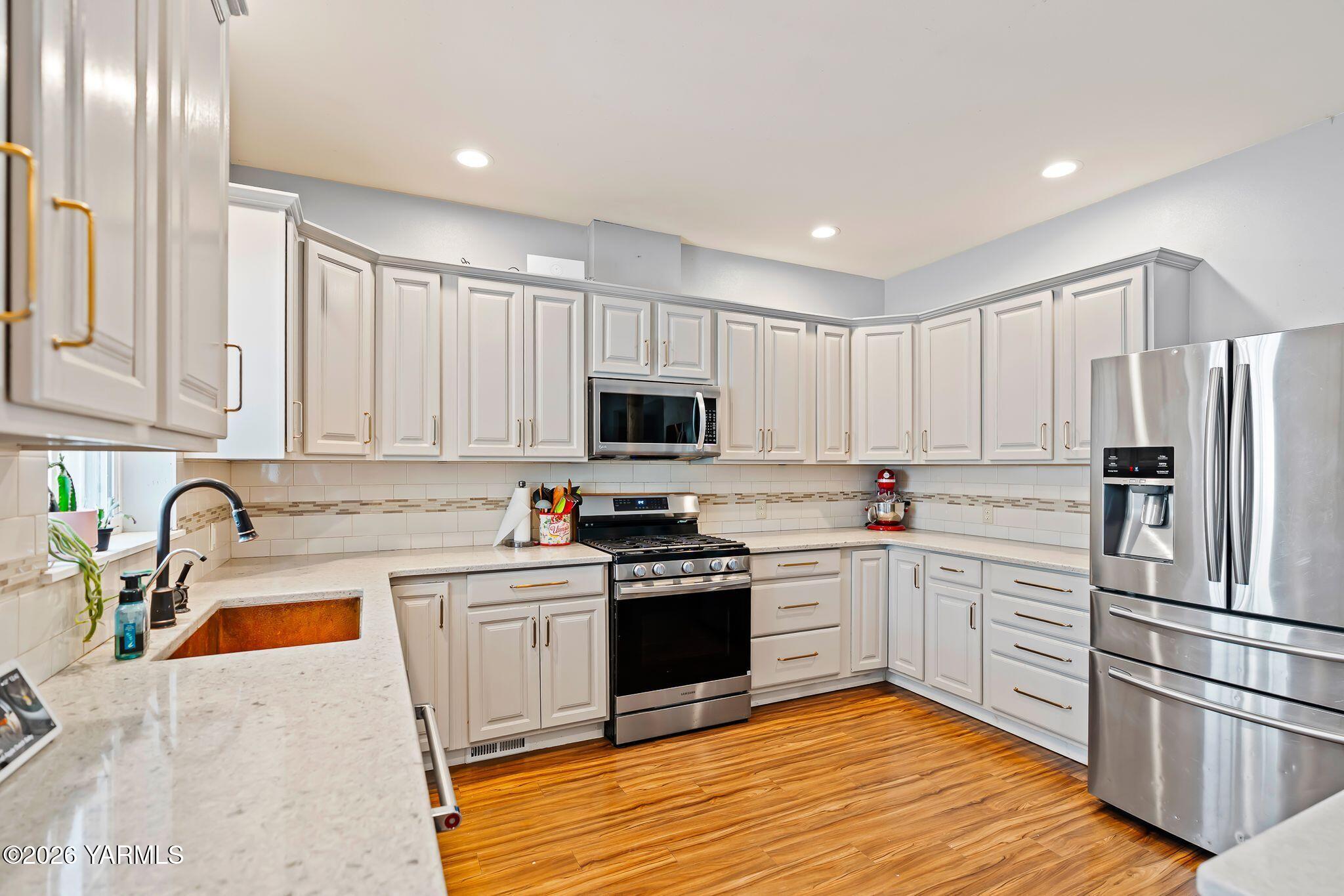 321 Gangl Road Wapato, WA 98951 - Photo 53 of 54 a kitchen with stainless steel appliances granite countertop a refrigerator sink and white cabinets