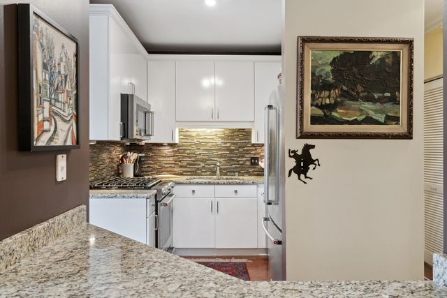 a kitchen with stainless steel appliances granite countertop a stove a sink and a microwave