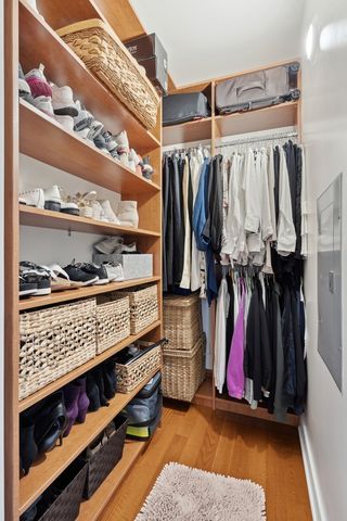 a view of walk in closet with clothes and shoes