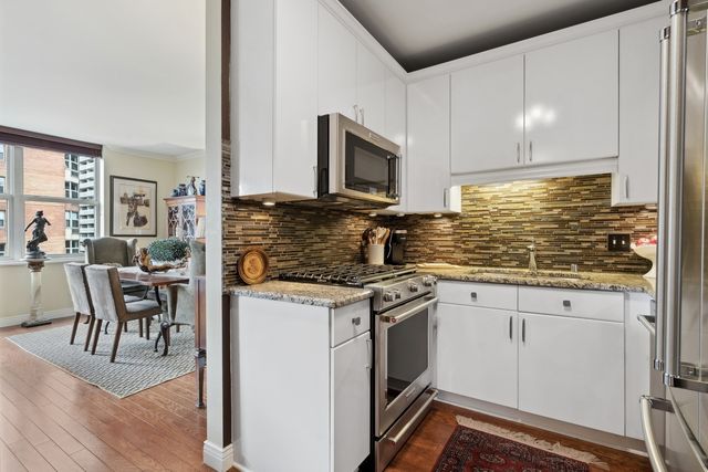 a kitchen with stainless steel appliances granite countertop a stove a sink and a microwave