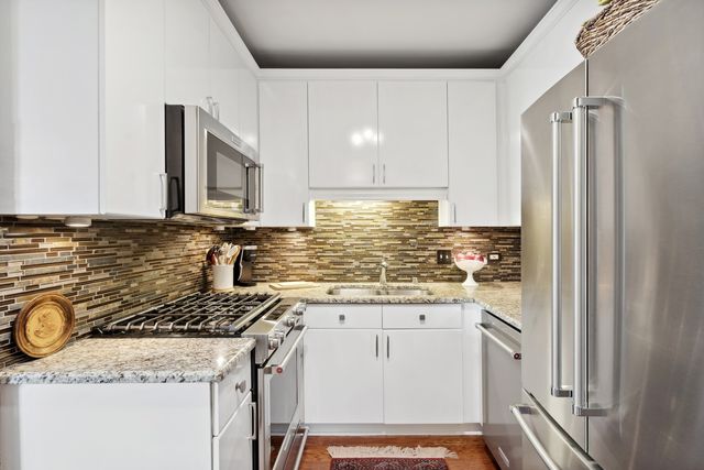 a kitchen with a sink a stove cabinets and refrigerator