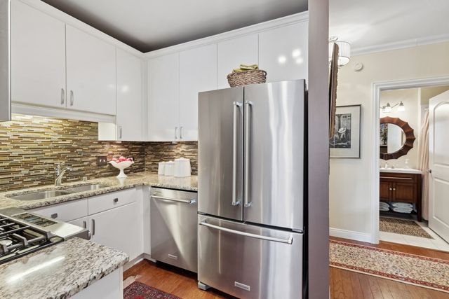 a kitchen with stainless steel appliances granite countertop a refrigerator and a stove