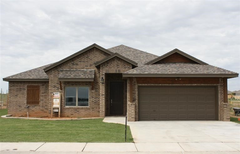 a front view of a house with a garden and yard