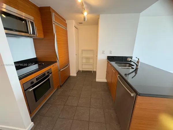 a kitchen with stainless steel appliances a refrigerator and a stove top oven