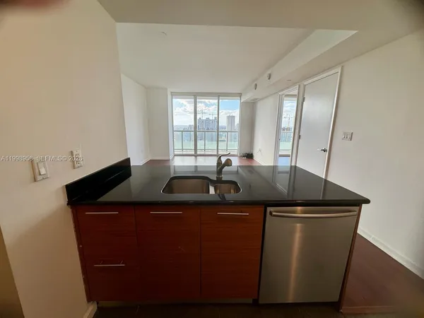a kitchen with granite countertop a sink and cabinets